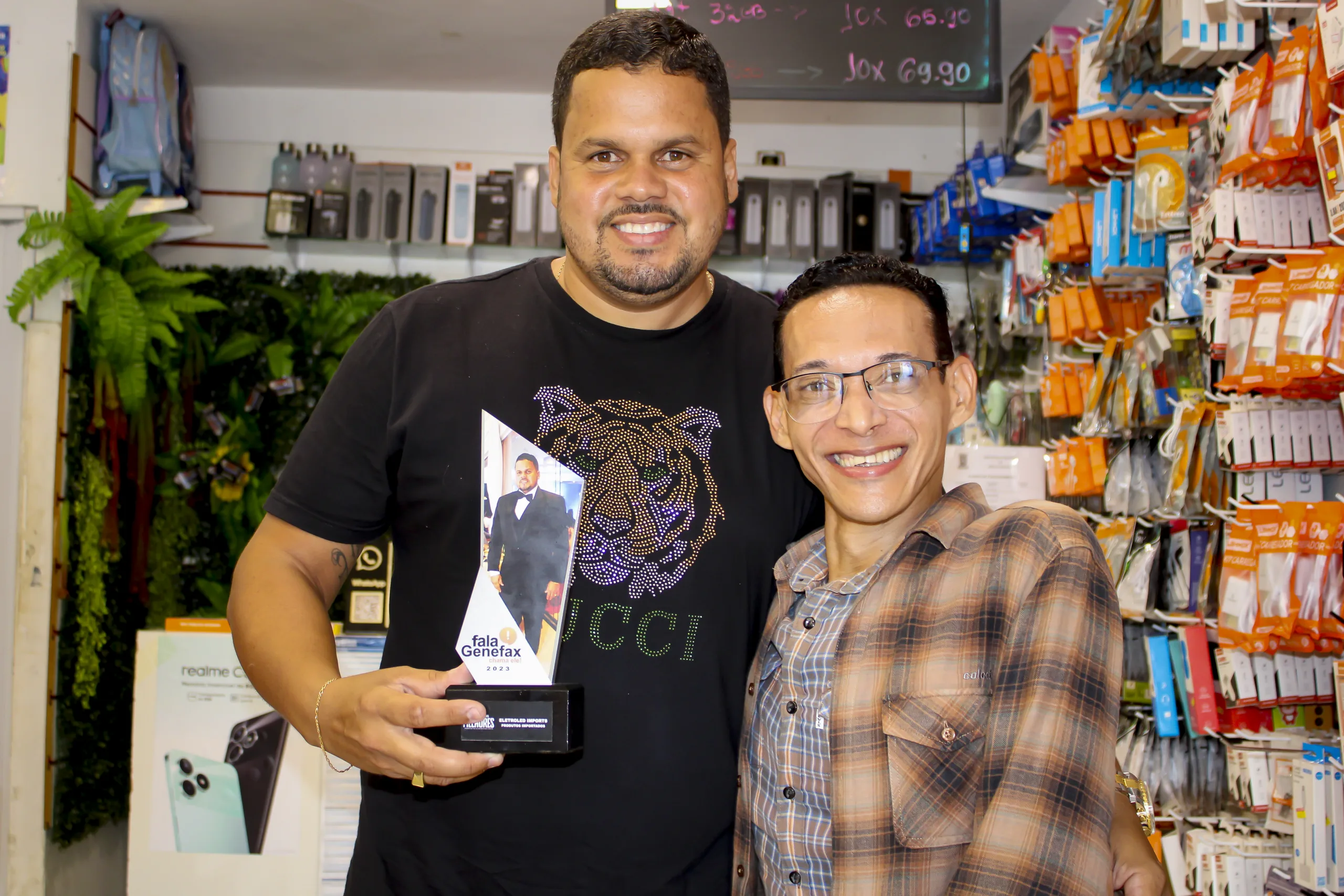 Jornalista Genefax entregou troféu a Victor das Neves, proprietário da Eletroled Imports. Foto: FALA GENEFAX